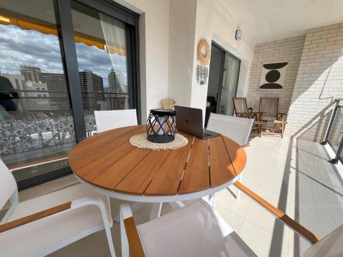 a dining room table with a laptop on it at Gemelos 24 Cala de Finestrat. Luxury Apt. in Benidorm
