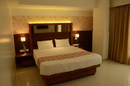 ein Schlafzimmer mit einem großen Bett und zwei Nachttischen in der Unterkunft SriKrishna Paradise Hotel Thane Navi Mumbai in Thane