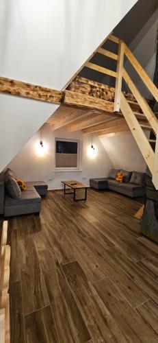 a living room with a loft bed and a wooden floor at Sylwia Aparthouse - Biały Dunajec in Biały Dunajec
