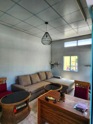un soggiorno con divano e tavolo di Seven Nine Hostel - Calm place to sleep a Baan Tai