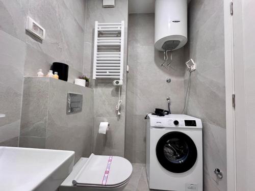 uma casa de banho com uma máquina de lavar roupa e um WC em White Homes 105 - Central Point em Podgorica