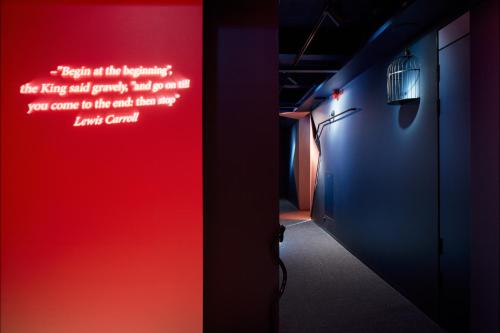 a hallway with a red and blue wall with writing on it at Zzz Dreamscape Hotel in Stockholm