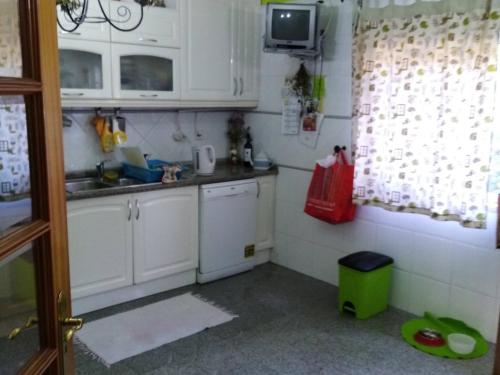 a small kitchen with white cabinets and a sink at Global Guests in Sintra