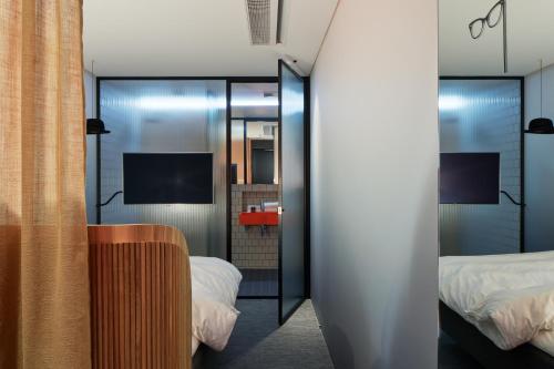 a room with two beds and a mirror at Zzz Dreamscape Hotel in Stockholm