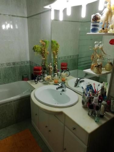 a bathroom with a sink and a tub and a mirror at Global Guests in Sintra