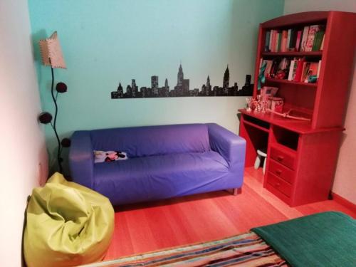 a living room with a purple couch and a book shelf at Global Guests in Sintra