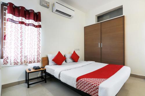 - une chambre avec un grand lit et des oreillers rouges dans l'établissement Flagship Bella Vagues Kovalam, à Covelong