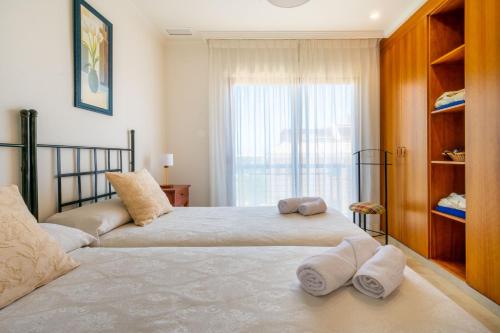 two beds in a bedroom with towels on them at Apartamentos Albir Confort 3 dormitorios in Albir