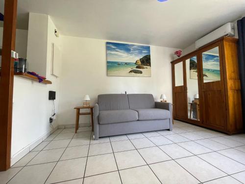 a living room with a couch on a tiled floor at La Plage Dorée in Saint-Pierre
