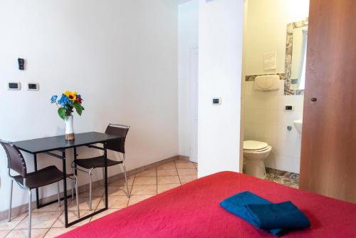 a bedroom with a table with a vase of flowers at Fruit Rooms in Rome