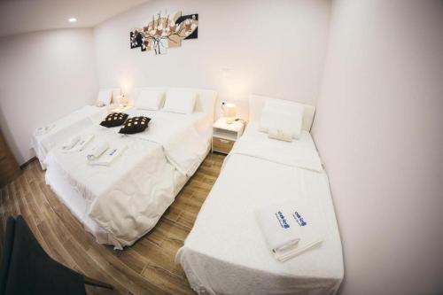 a room with two beds with white sheets and towels at Adria centar Koćuša in Ljubuški