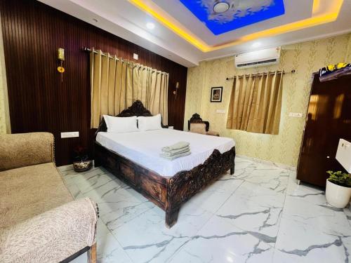 a bedroom with a king sized bed and a couch at PAGDANDI VILLA BY ALOHA in Udaipur