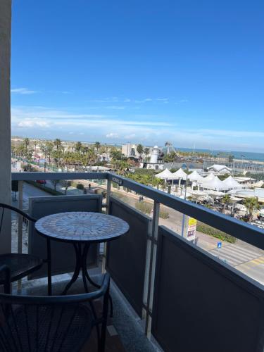 a table and chairs on a balcony with a view of the beach at Hotel Touring in Sottomarina