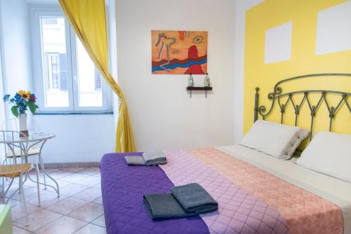 a bedroom with a bed with two towels on it at Fruit Rooms in Rome