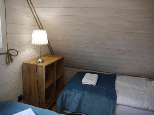 a bedroom with a bed and a lamp on a table at Dziedziniec Karkonoszy in Podgórzyn
