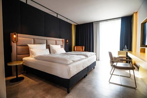um quarto com uma cama, uma mesa e uma cadeira em Scheck Hotel em Munique