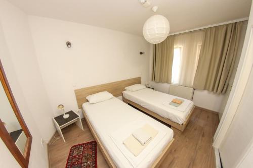 a small room with two beds and a window at Hotel Hayat in Sarajevo