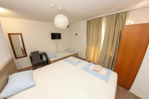 a bedroom with a large white bed and a mirror at Hotel Hayat in Sarajevo