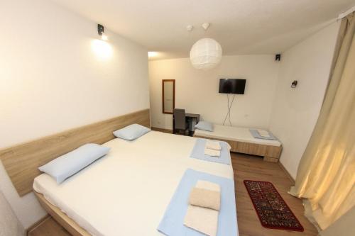 a small room with two beds and a television at Hotel Hayat in Sarajevo