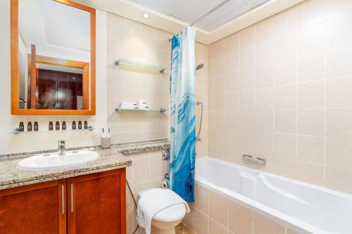 Lux BnB I Una Tower I Lakes View في دبي: حمام مع حوض ومرحاض وحوض استحمام