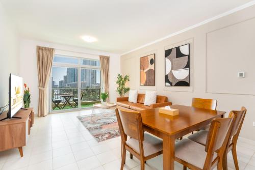 a living room with a table and a couch at Lux BnB I Una Tower I Lakes View in Dubai