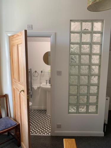 a bathroom with a glass door with a sink at Ocean view double with ensuite, with access to private garden and bike store in Kent