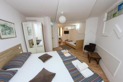 a bedroom with a large white bed and a living room at Hotel Hayat in Sarajevo