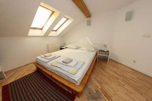 a bedroom with a bed with white sheets and a window at Hotel Hayat in Sarajevo