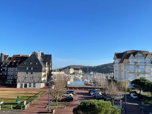 une ville avec des voitures garées dans un parking dans l'établissement Appartement cosy vue port, à Dives-sur-Mer