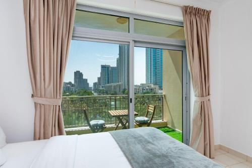 a bedroom with a bed and a view of the city at Lux BnB I Una Tower I Lakes View in Dubai