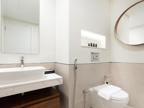 a bathroom with a sink and a toilet and a mirror at Lux BnB I Asayel I Burj Al Arab & Burj View in Dubai