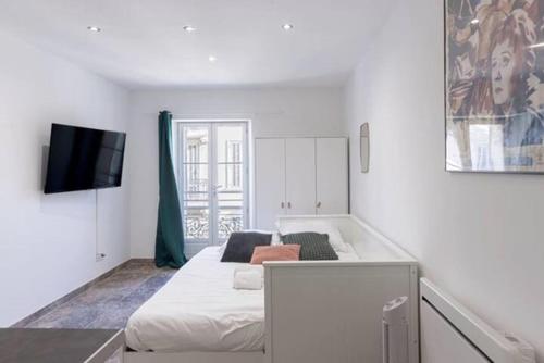 Cette chambre blanche dispose d'un lit et d'une télévision. dans l'établissement Studio centre de Cannes, à Cannes