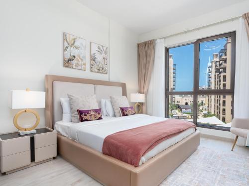 a bedroom with a large bed and a large window at Lux BnB I Asayel I Burj Al Arab & Burj View in Dubai