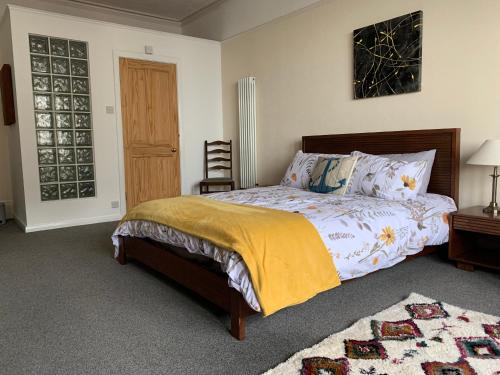a bedroom with a bed and a chair and a window at Ocean view double with ensuite, with access to private garden and bike store in Kent