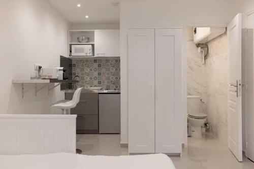 - une cuisine blanche avec une chaise blanche dans la chambre dans l'établissement Studio centre de Cannes, à Cannes