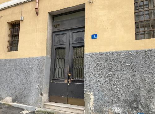 uma porta preta num edifício com janelas em La Mansarda di Pino em Trieste
