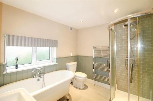 a bathroom with a tub and a toilet and a sink at NEW Thirsk Stays - Herriot's Hideaway in Thirsk