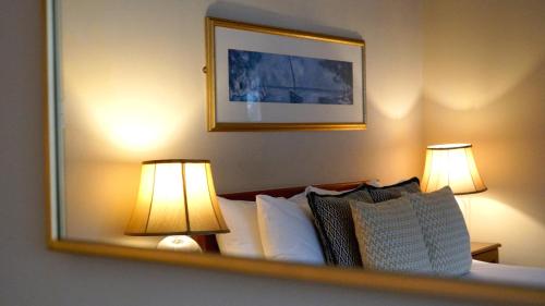 a hotel room with a bed with two lamps at The Red Lion Eaton in Norwich
