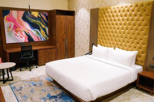 a bedroom with a large white bed and a desk at Enrise by Sayaji Nagpur in Nagpur