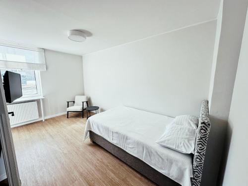 Habitación blanca con cama y TV en VILMSI 52 APARTMENTS, en Tallin