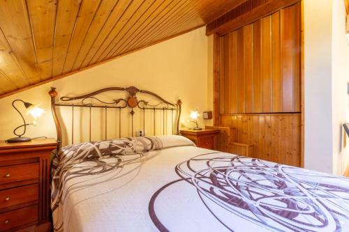 ein Schlafzimmer mit einem großen Bett und einer Holzdecke in der Unterkunft Apartamento Ático Duplex Santa Pola in Santa Pola