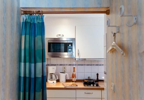 une cuisine avec un évier et un micro-ondes dans l'établissement Jule im Haus Wega, à Westerland