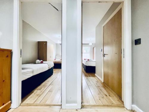 Habitación con 2 camas y puerta a un dormitorio en Lovely 4 bed (sleeps 8) apartment close to city, en Mánchester