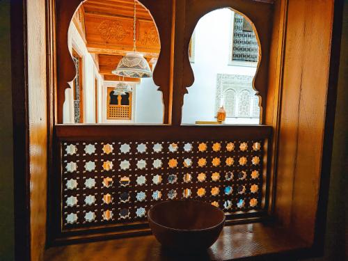 una ventana con un bol sobre una mesa en una habitación en Riad Fès Center, en Fez