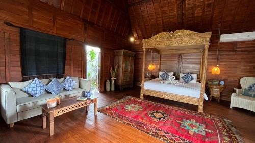a bedroom with a bed and a couch and a table at Jabunami Villa in Canggu