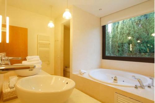 baño con bañera grande y lavamanos en Chalet moderno en Sotogrande costa, en San Roque