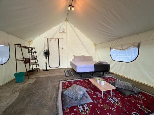 a tent with a bed and a table in it at Glamping at Xscape Tambun in Tambun