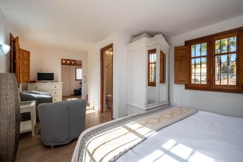 a bedroom with a bed and a desk and a kitchen at Casa Amarilla Casitas in Alhaurín el Grande