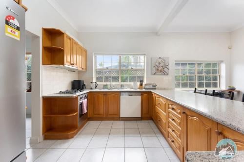 a kitchen with wooden cabinets and white appliances at Aircabin - Blakehurst - Spacious - 5 Beds House in Sydney