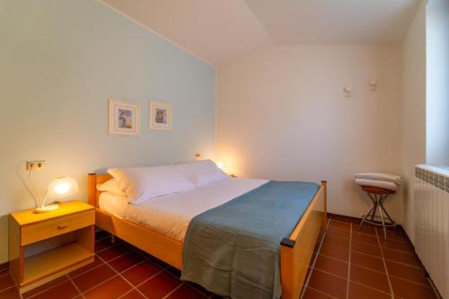 a small bedroom with a bed and a night stand at Marigold Apartment by Wonderful Italy in Bellagio